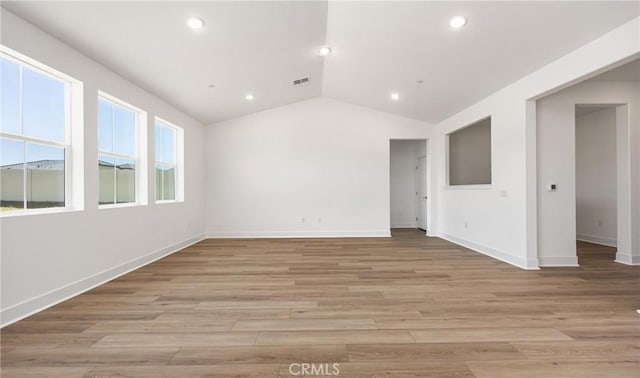 spare room featuring lofted ceiling, recessed lighting, baseboards, and light wood-style flooring