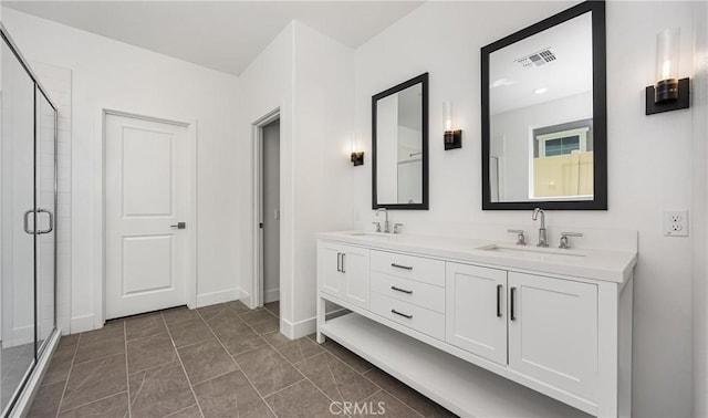 full bath with a shower stall, double vanity, and baseboards