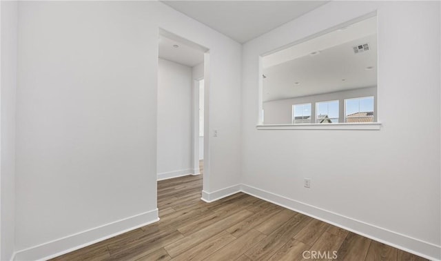 empty room with baseboards and wood finished floors