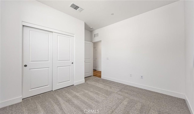 unfurnished bedroom featuring carpet flooring, a closet, and baseboards