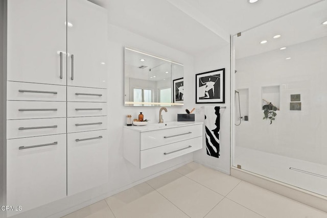 bathroom with tile patterned floors, a shower with door, and vanity