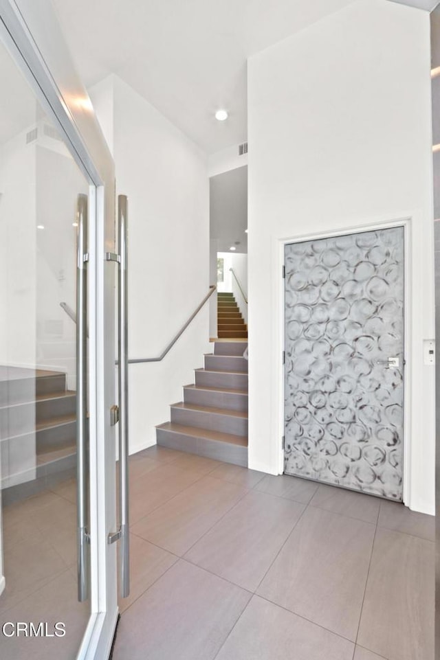 stairway featuring tile patterned flooring