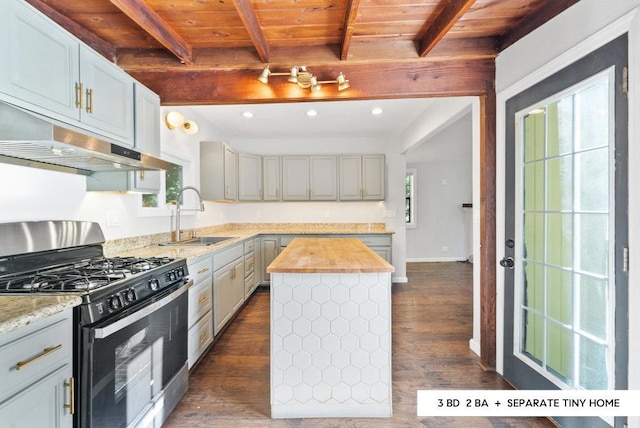 kitchen with butcher block counters, gas stove, wood ceiling, a kitchen island, and beam ceiling