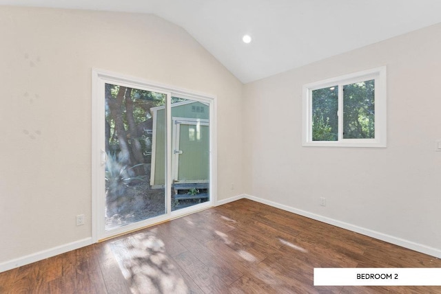 spare room with lofted ceiling, plenty of natural light, and hardwood / wood-style floors