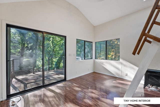 doorway with hardwood / wood-style flooring and high vaulted ceiling