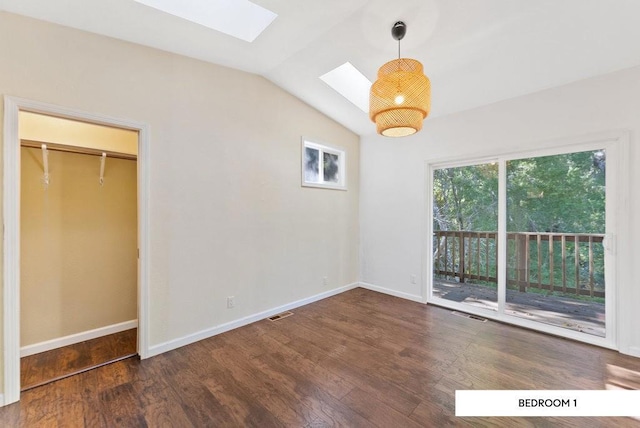 unfurnished bedroom featuring access to exterior, dark wood-type flooring, lofted ceiling with skylight, and a closet