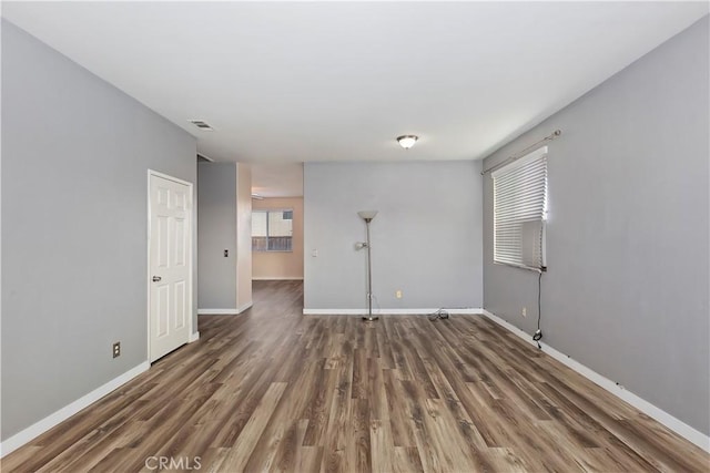 spare room with dark hardwood / wood-style flooring and a wealth of natural light