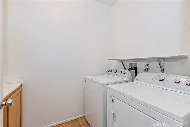 washroom with washer and dryer, cabinets, and light tile patterned floors