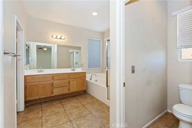 bathroom featuring vanity, ceiling fan, tile patterned flooring, tiled bath, and toilet