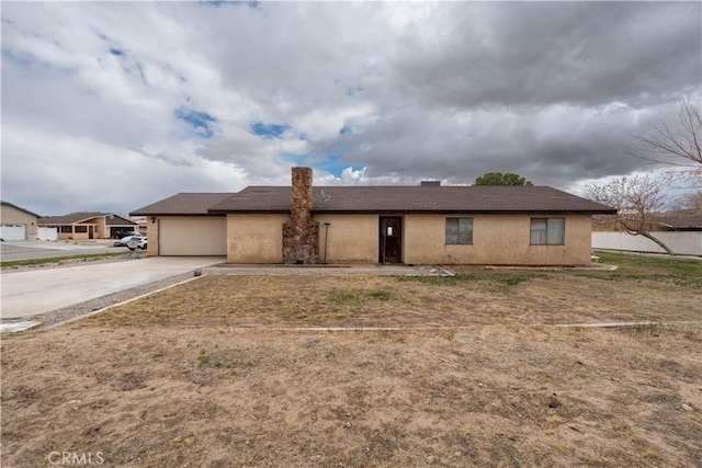 view of front of home with stucco siding, driveway, and a garage