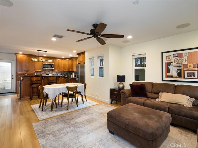 living room featuring ceiling fan and light wood-type flooring