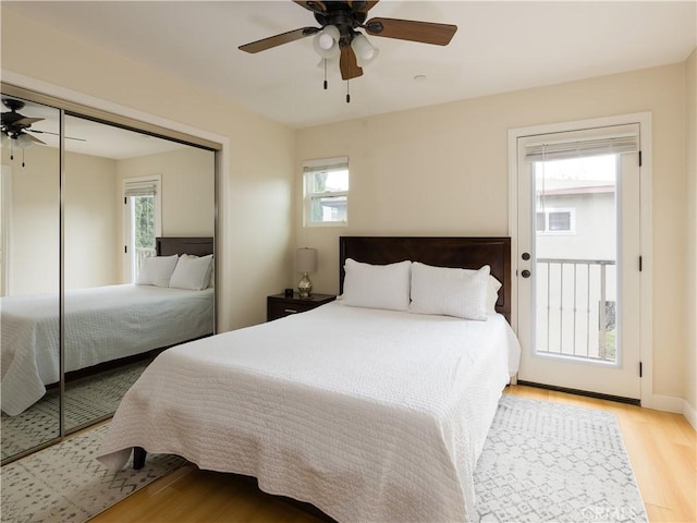 bedroom featuring multiple windows, ceiling fan, light wood-type flooring, and a closet