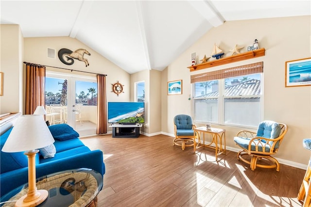 living area featuring lofted ceiling, french doors, and light hardwood / wood-style floors