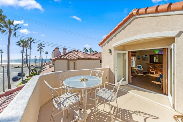 view of patio with a water view and a balcony