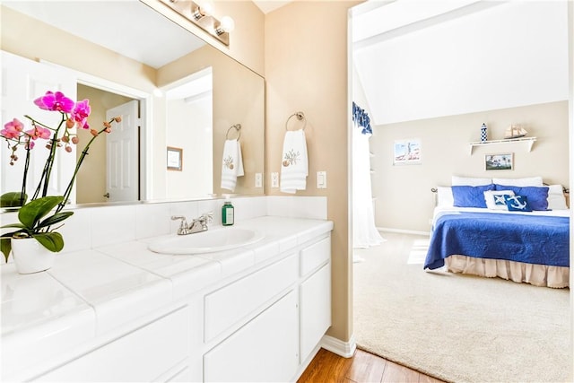 bathroom featuring wood finished floors, vanity, and baseboards