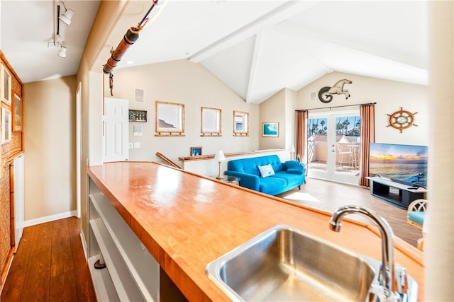 kitchen featuring dark hardwood / wood-style flooring, lofted ceiling, french doors, and sink