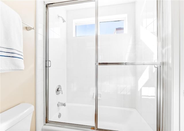 full bathroom with shower / bath combination with glass door and toilet