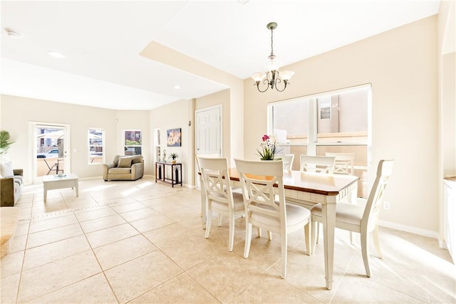 dining room featuring baseboards, light tile patterned flooring, and a notable chandelier