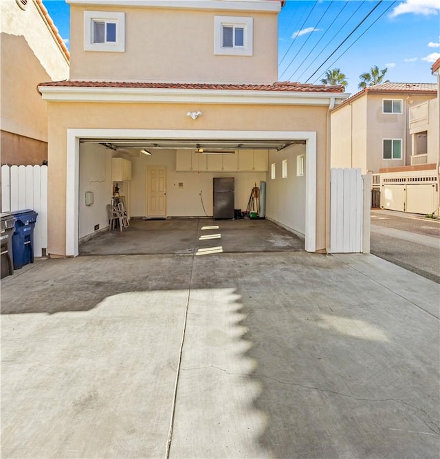 garage featuring driveway and fence