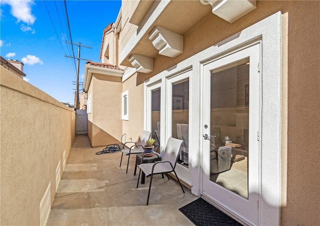 view of patio / terrace featuring fence and french doors