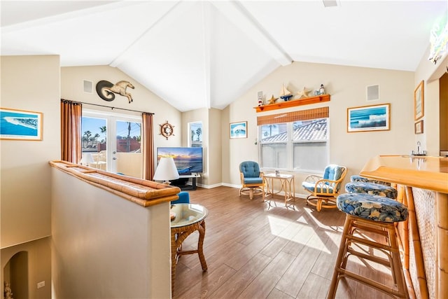 sitting room featuring baseboards, visible vents, wood finished floors, vaulted ceiling with beams, and french doors