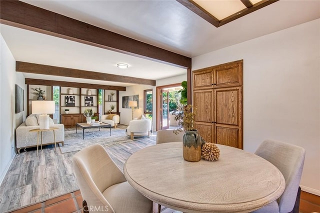 dining space featuring wood-type flooring and beam ceiling