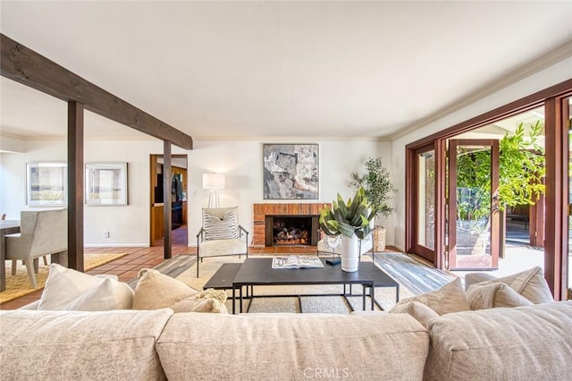 living room with crown molding, a fireplace, and beamed ceiling