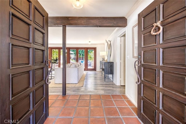 tiled entryway with french doors, beamed ceiling, and ornamental molding