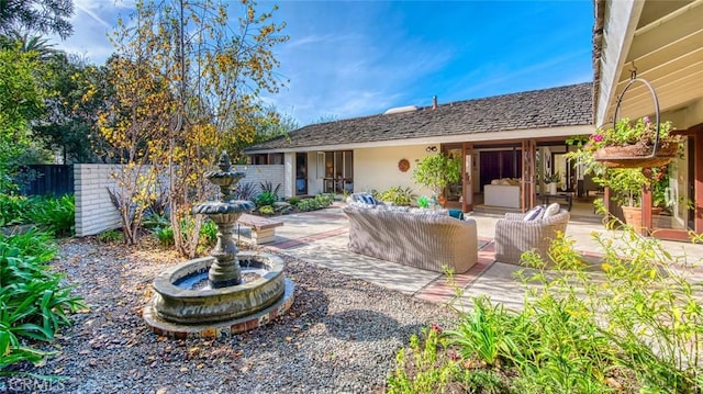 rear view of house with an outdoor living space and a patio