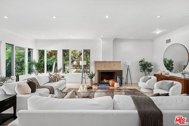 living room featuring a high end fireplace and ornamental molding