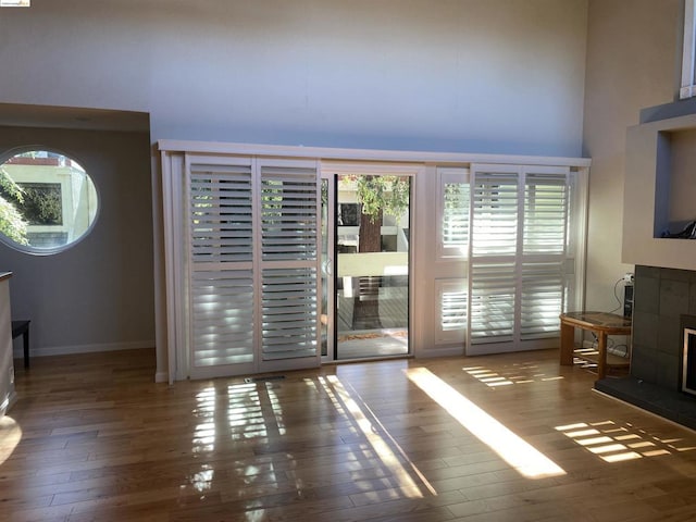 doorway to outside featuring a towering ceiling and dark wood-type flooring