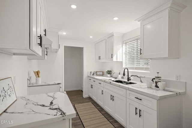 kitchen featuring white cabinets, dark wood-type flooring, sink, and light stone counters