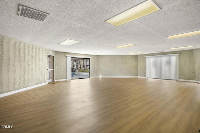 empty room with a textured ceiling and hardwood / wood-style floors