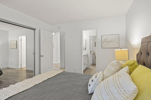 bedroom featuring a textured ceiling and ensuite bath