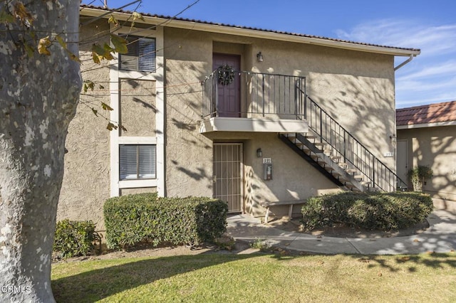 exterior space featuring a balcony and a front lawn