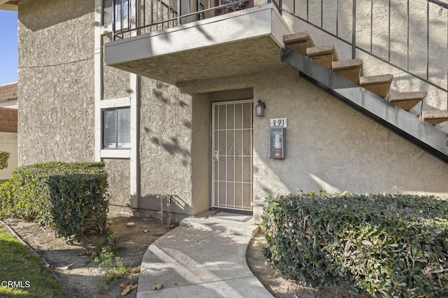 view of exterior entry featuring a balcony