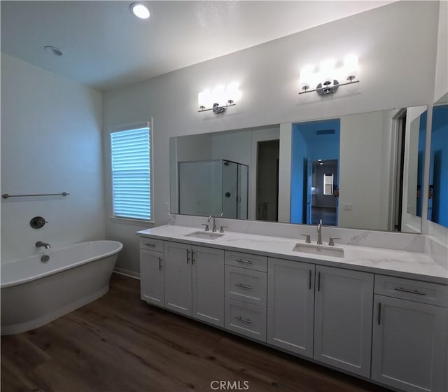 bathroom with hardwood / wood-style flooring, vanity, and separate shower and tub