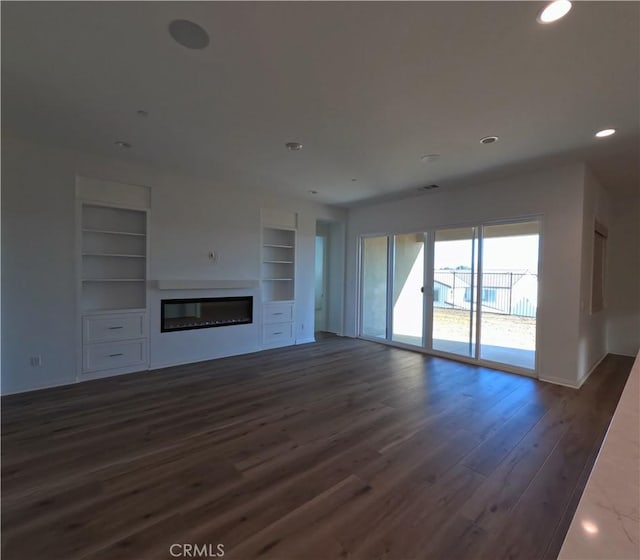 unfurnished living room with built in shelves and dark hardwood / wood-style flooring