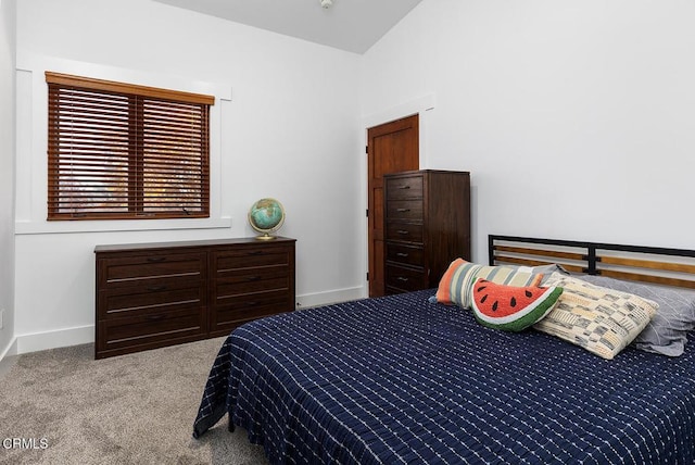 carpeted bedroom with lofted ceiling