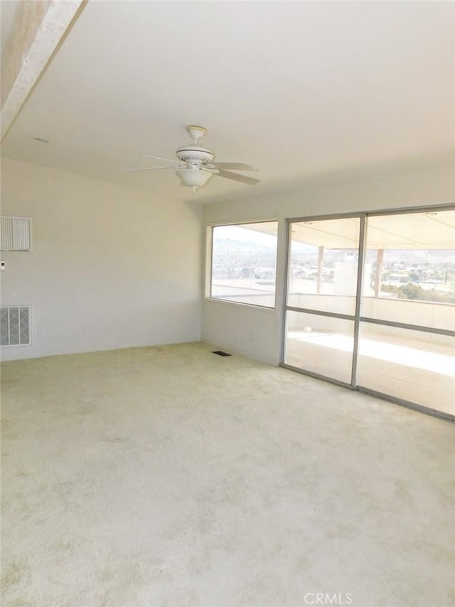 carpeted spare room featuring ceiling fan