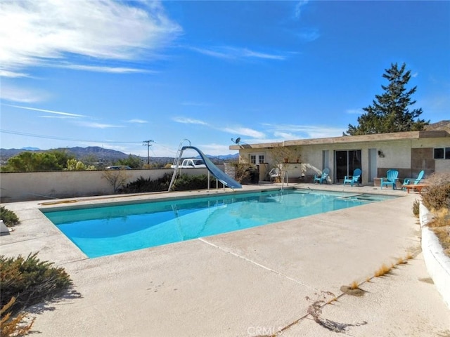 view of swimming pool featuring a water slide and a patio area