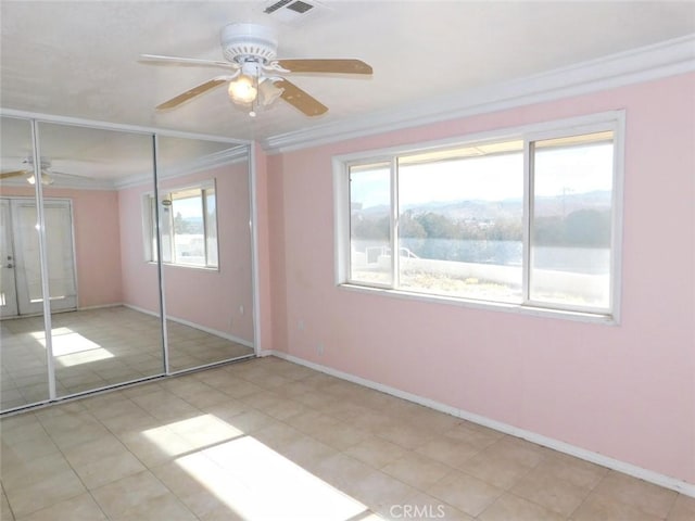 unfurnished bedroom with crown molding, a closet, ceiling fan, and multiple windows