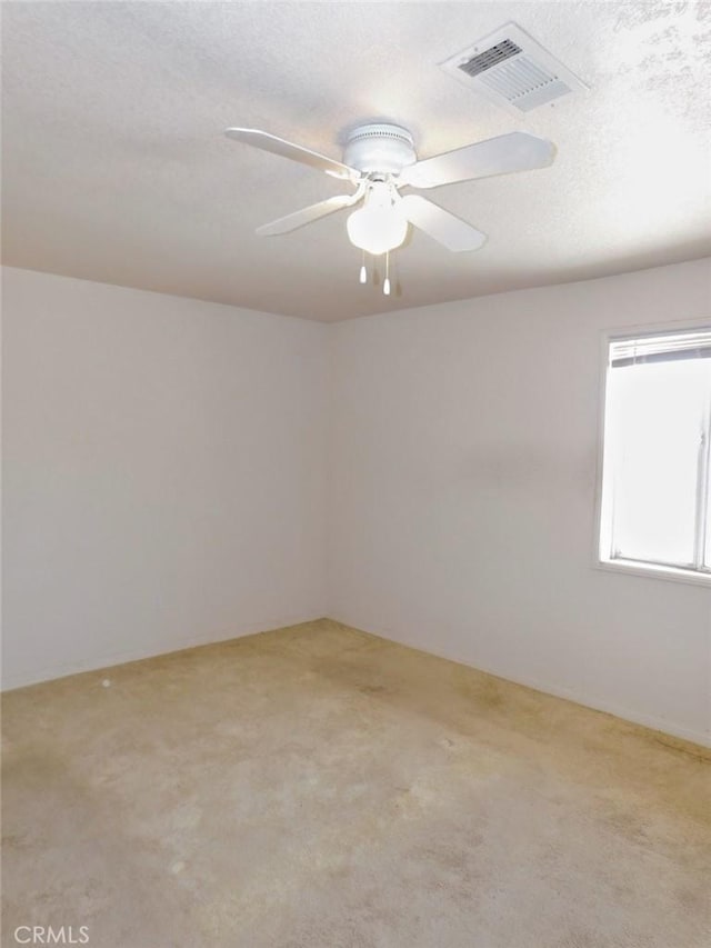 carpeted spare room with ceiling fan and a textured ceiling