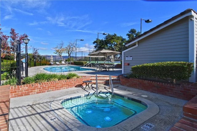 view of pool featuring a community hot tub and a patio area