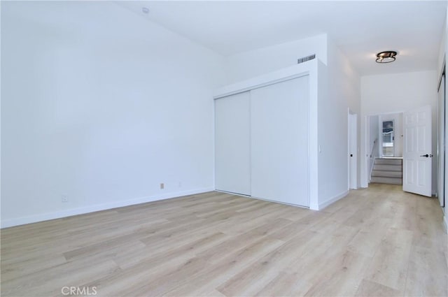 unfurnished bedroom featuring light wood-type flooring and a closet