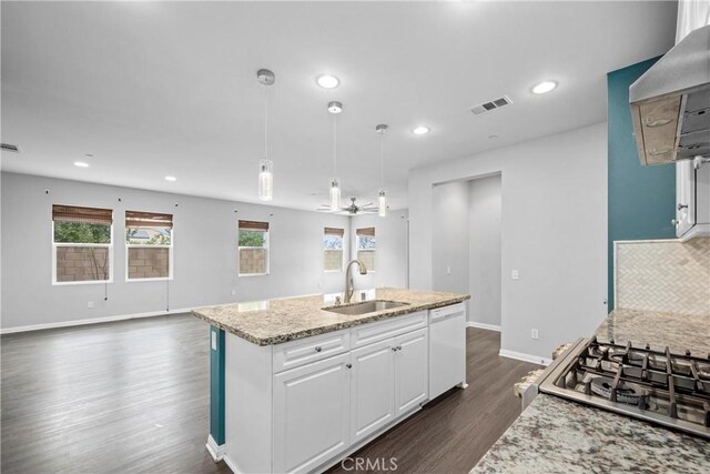 kitchen featuring ceiling fan, a kitchen island with sink, sink, decorative light fixtures, and white cabinets