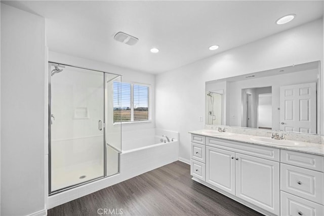 bathroom with hardwood / wood-style floors, vanity, and shower with separate bathtub