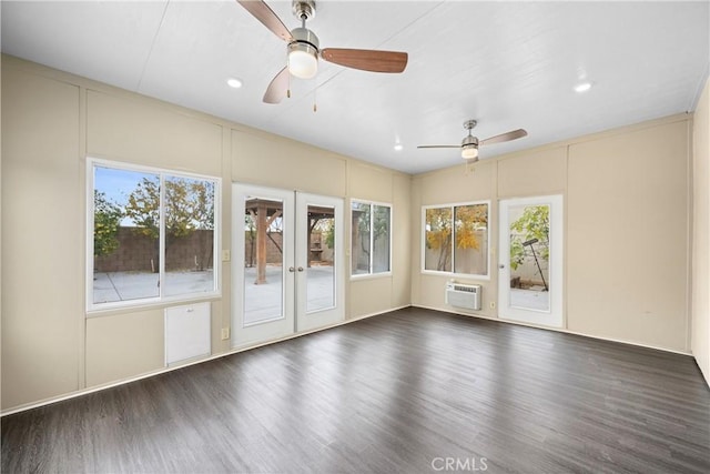 unfurnished sunroom with plenty of natural light, ceiling fan, a wall mounted AC, and french doors