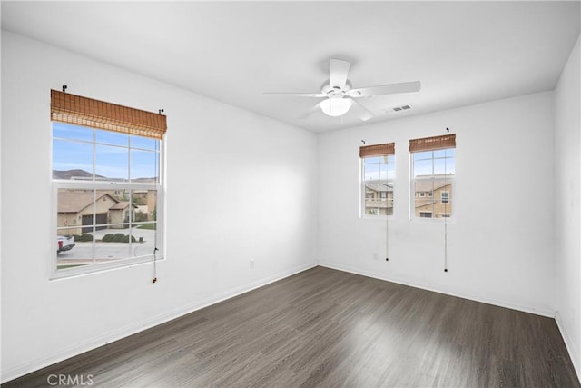 spare room with dark hardwood / wood-style floors and ceiling fan