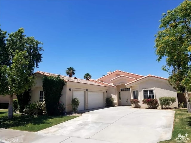 79534 Dandelion Dr, La Quinta, CA 92253 - mediterranean / spanish-style house with a garage, a tile roof, stucco siding, and driveway